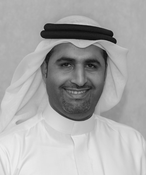 A black and white photo of a man smiling, representing House Me Bahrain company's commercial real estate services.
