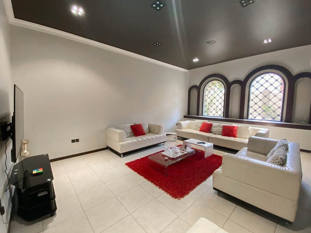 A breathtaking villa for sale in Saar with large windows and a fireplace.