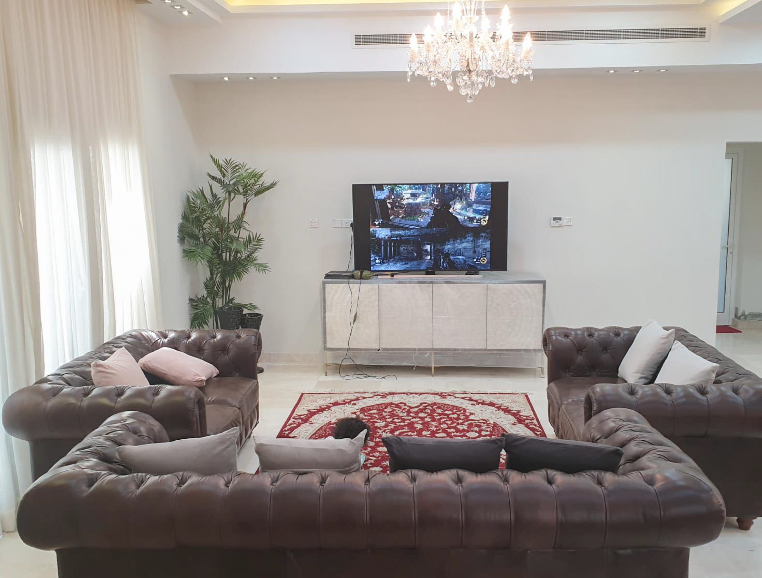 Luxury living room with couches and a TV in a 6BR villa for sale in Amwaj Area.