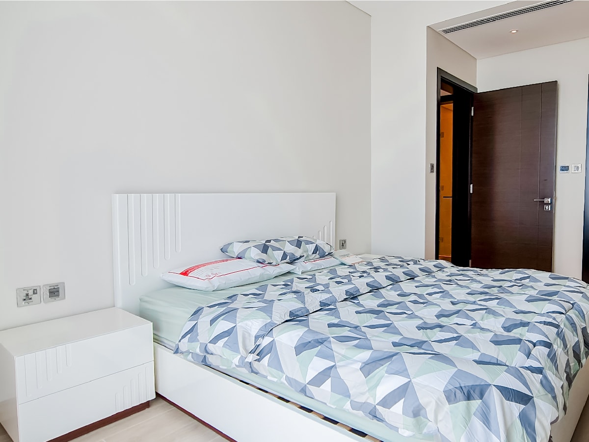 A charming bedroom with a bed and a dresser in a 2 Beds Apartment for Sale in Juffair.