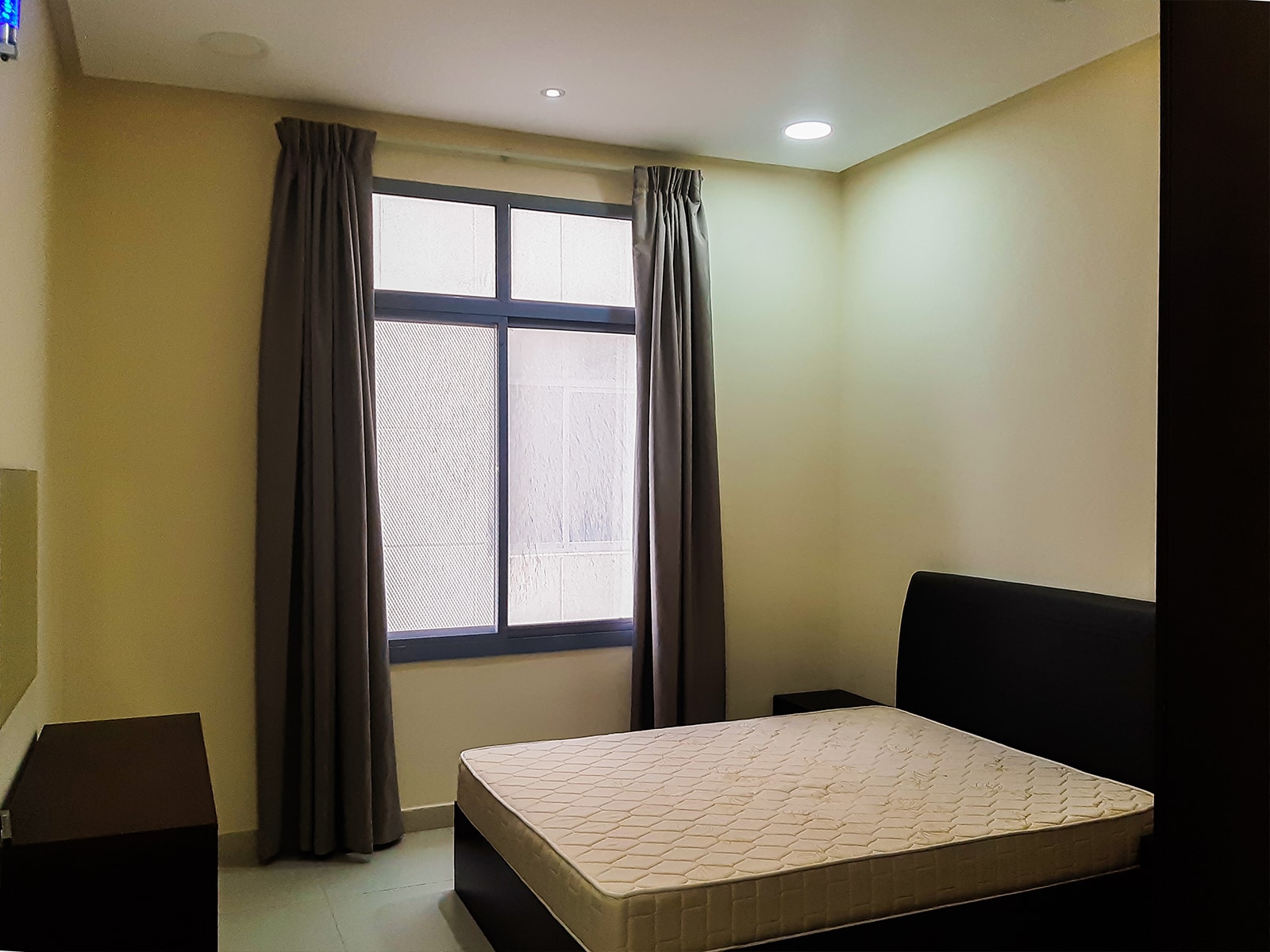 A furnished bedroom with a bed and a window in a 2BR apartment for rent in Adliya.