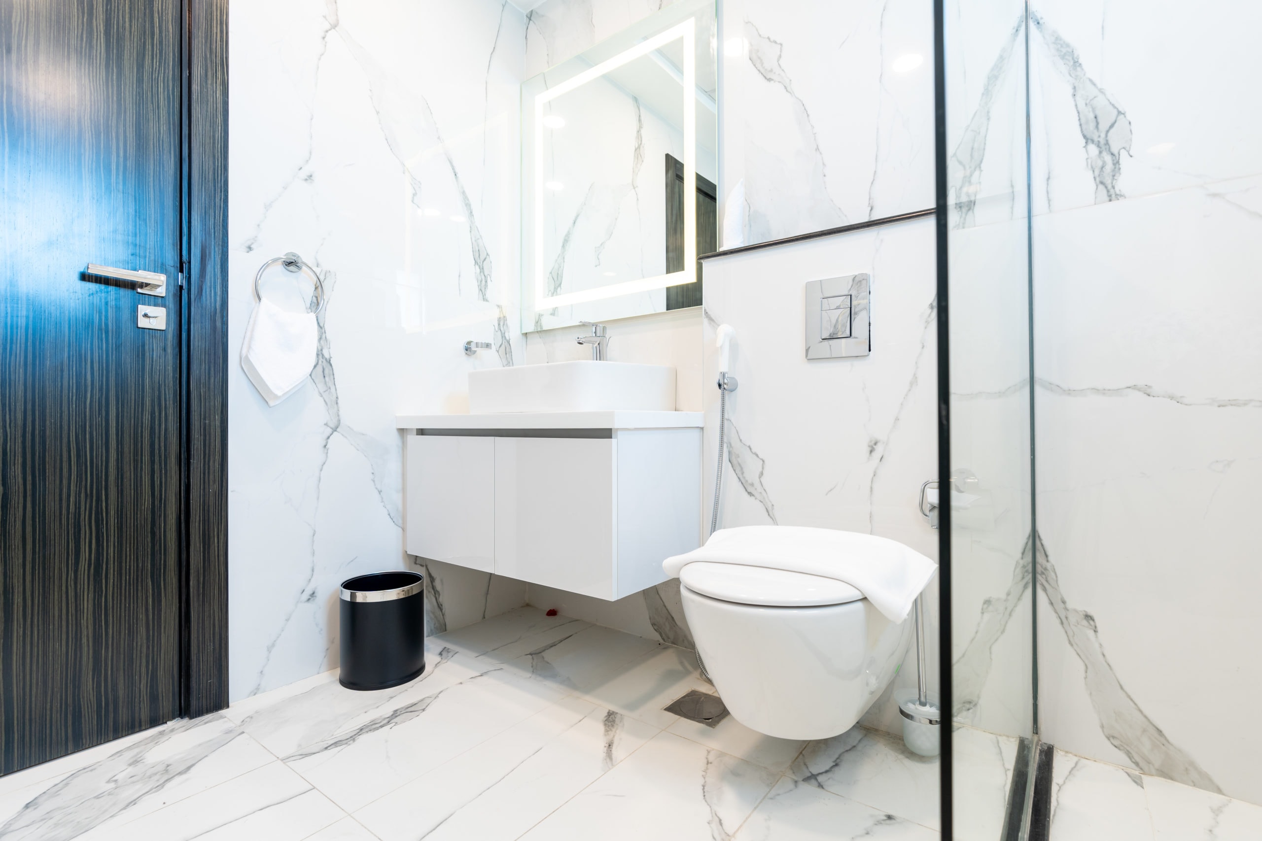 A spacious white bathroom with marble floors in an amazing new building.