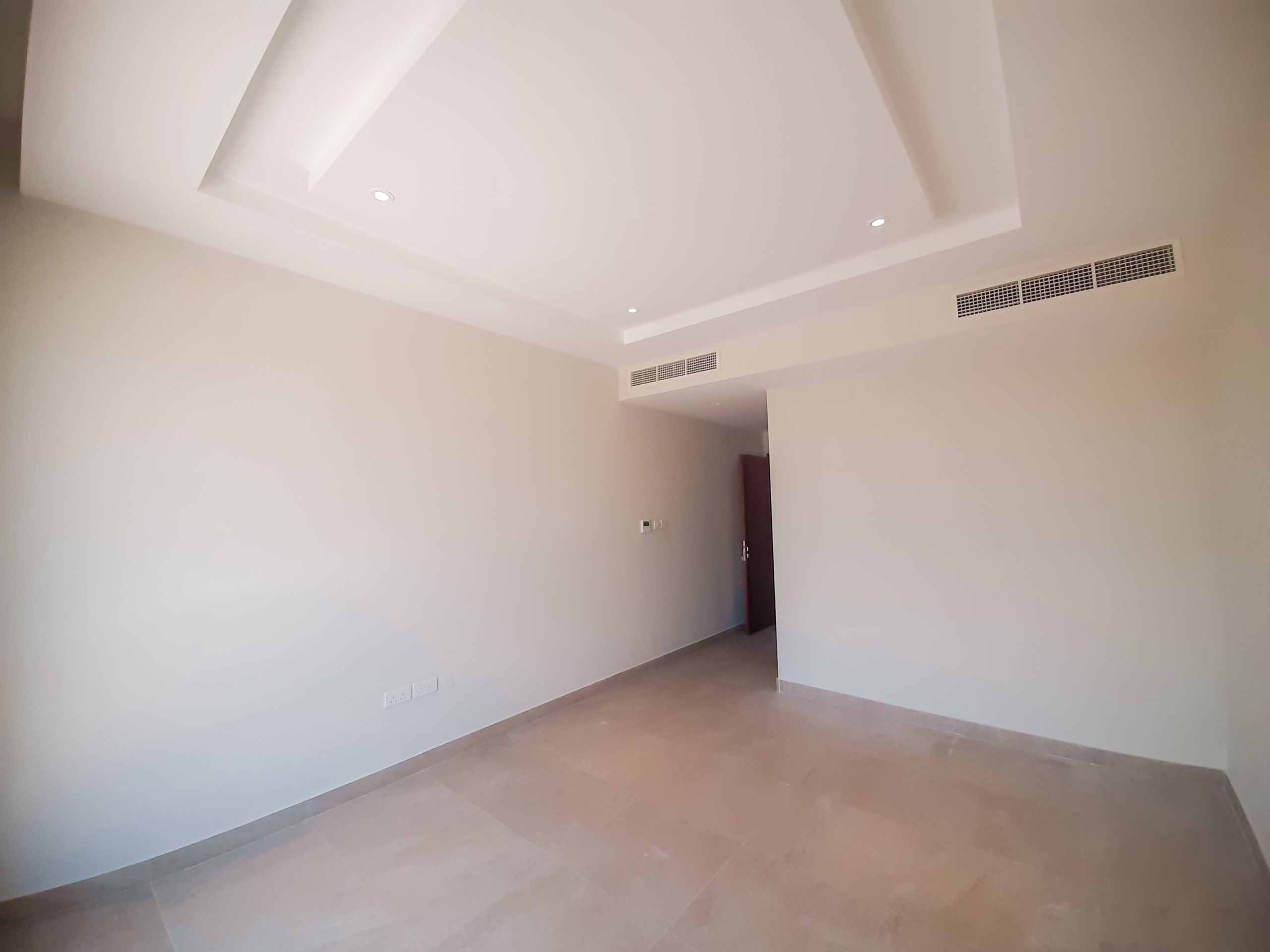 An empty room with white walls and ceiling available for rent.