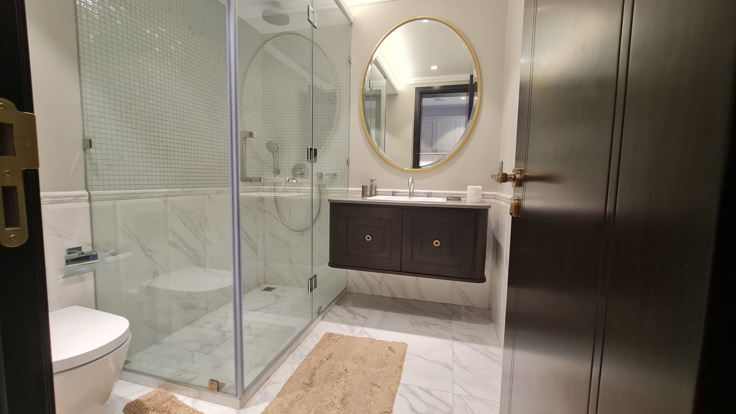 A beautiful bathroom with a glass shower stall and toilet in a great price.