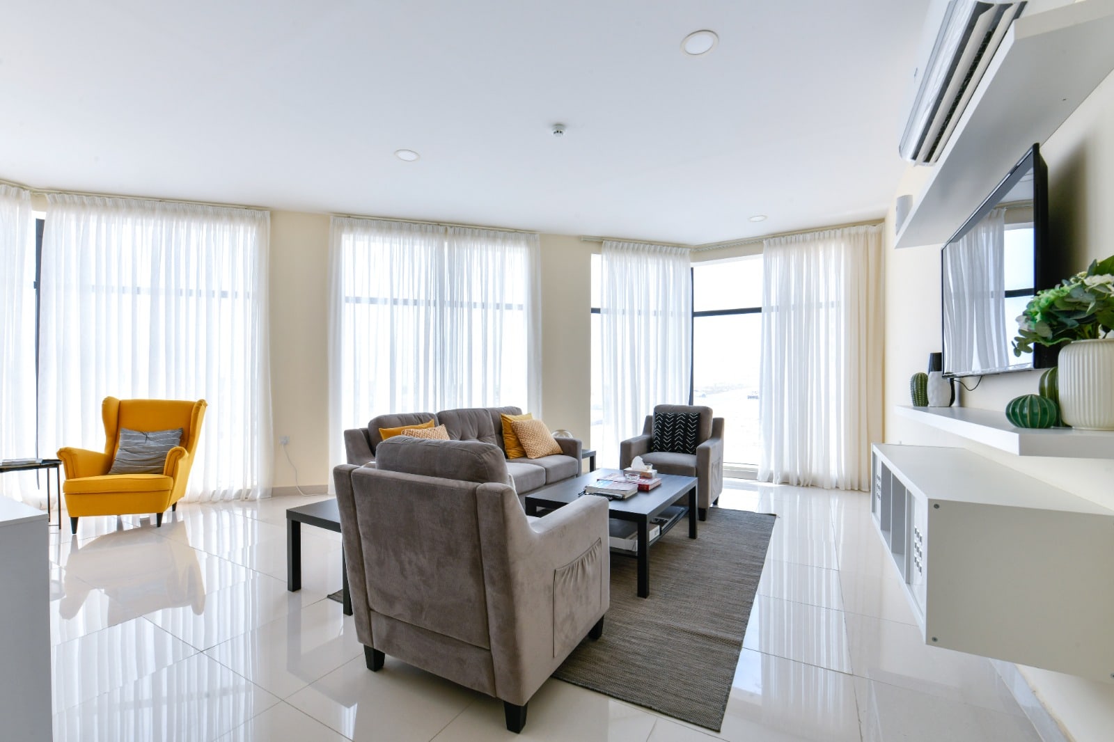 A stunning living room with white furniture and a large window.