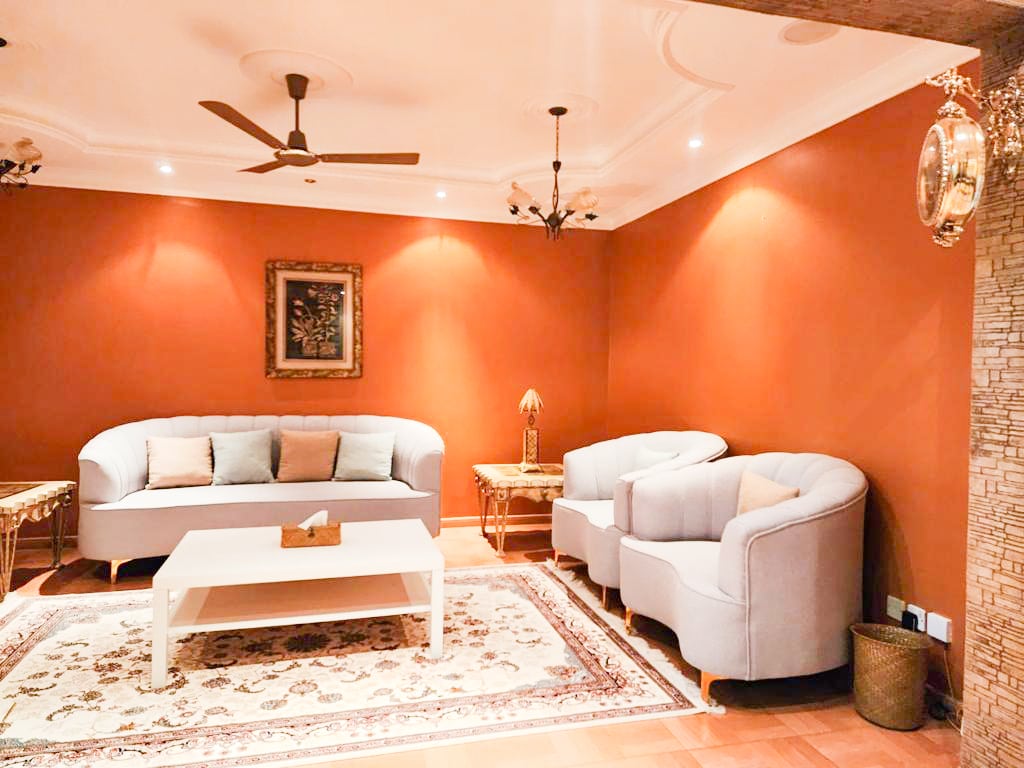 A luxury villa for sale in Hamad Town with orange walls and furniture.