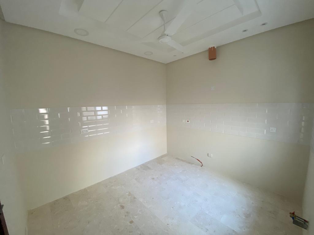 A luxurious room with white tiles and a ceiling fan.