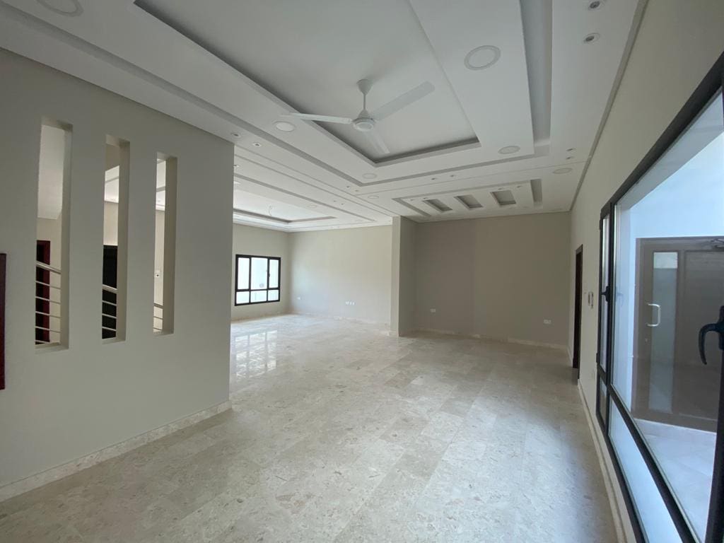 A luxurious white-walled room with a ceiling fan.