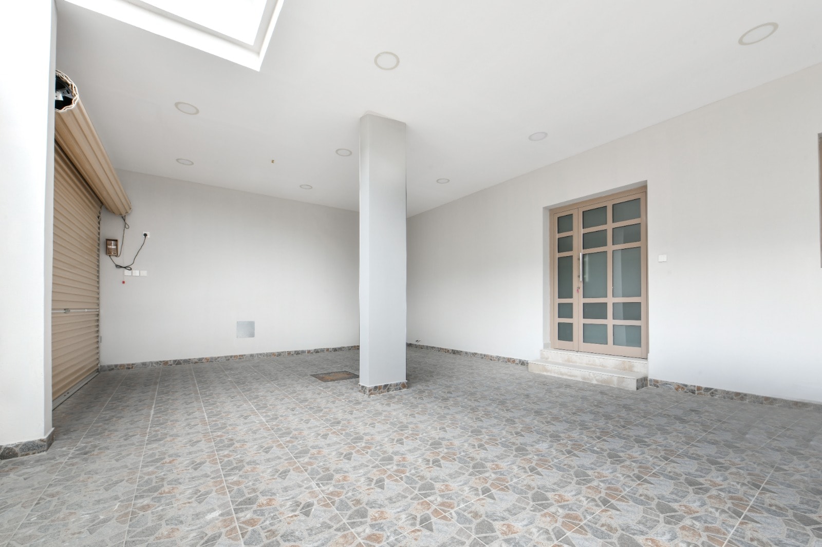 An empty room with tiled floors and a door in an amazing villa.