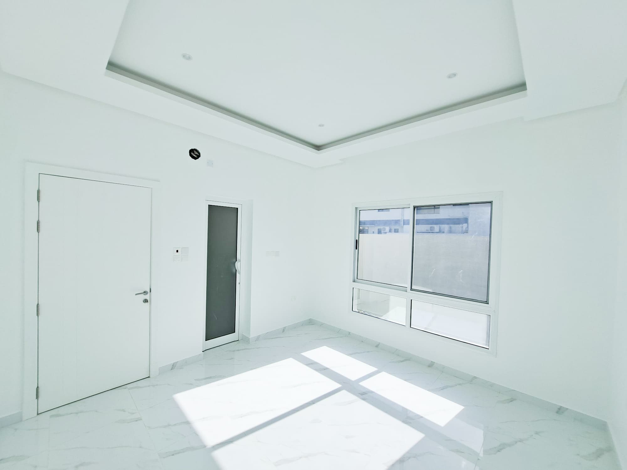 A luxury white room with a door and windows.