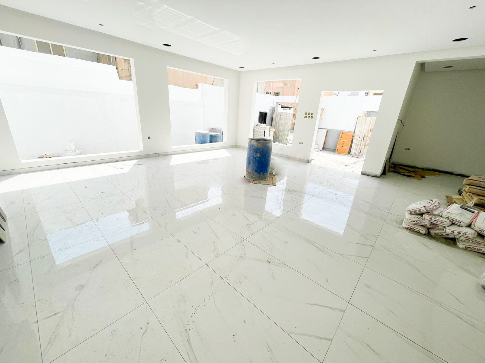 A white tiled floor in a huge room.