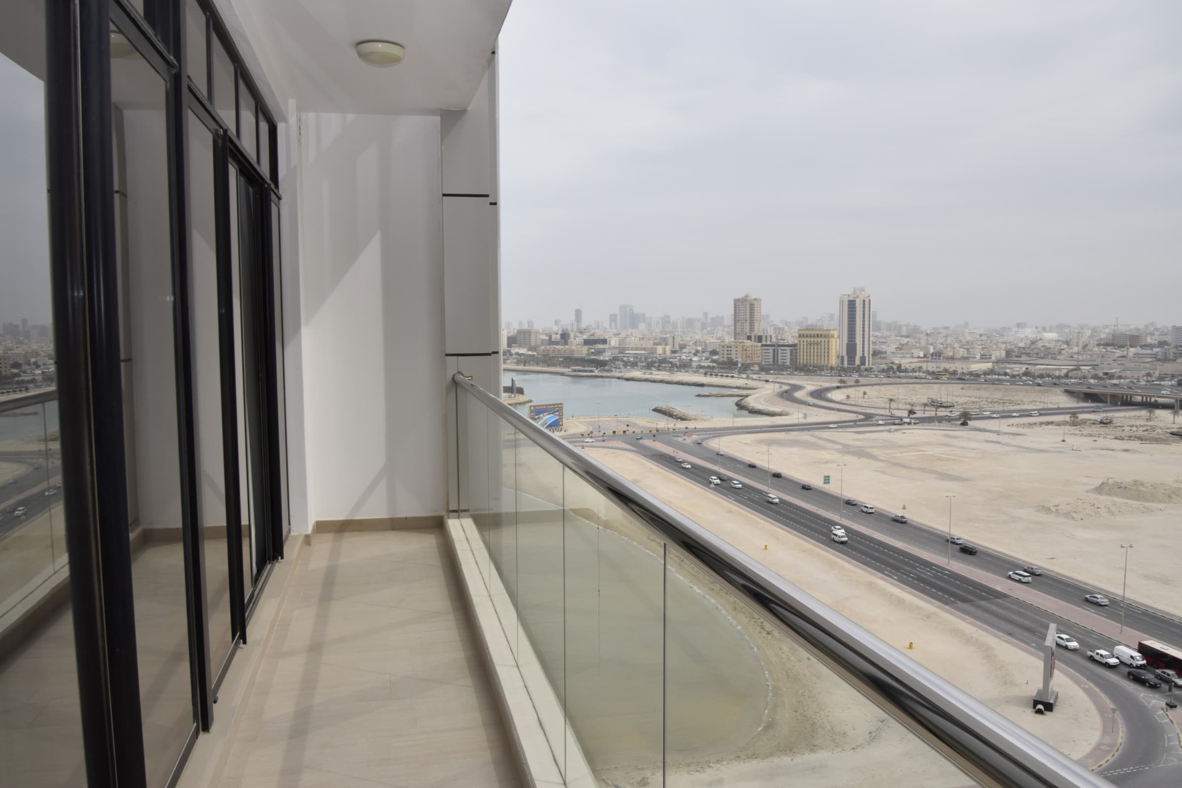 A fully furnished 1BR flat with a view of the city from a balcony overlooking the water.