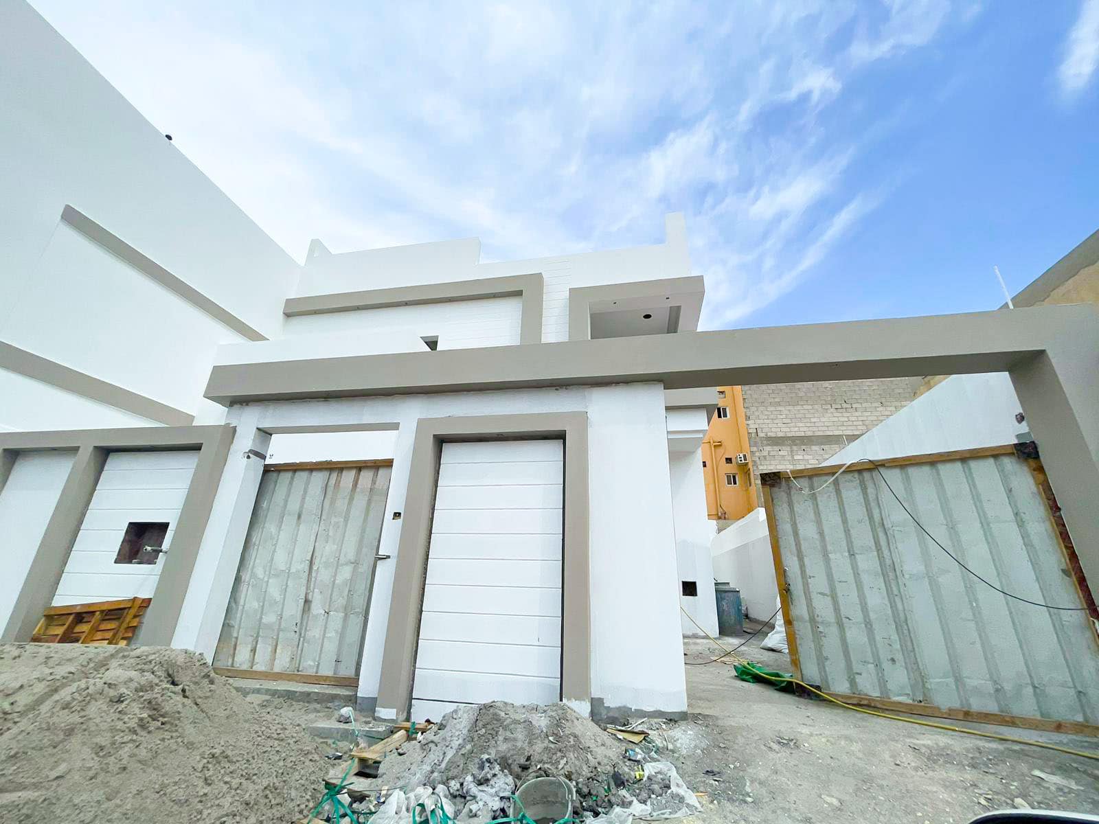 A luxury villa is being built in front of a construction site.