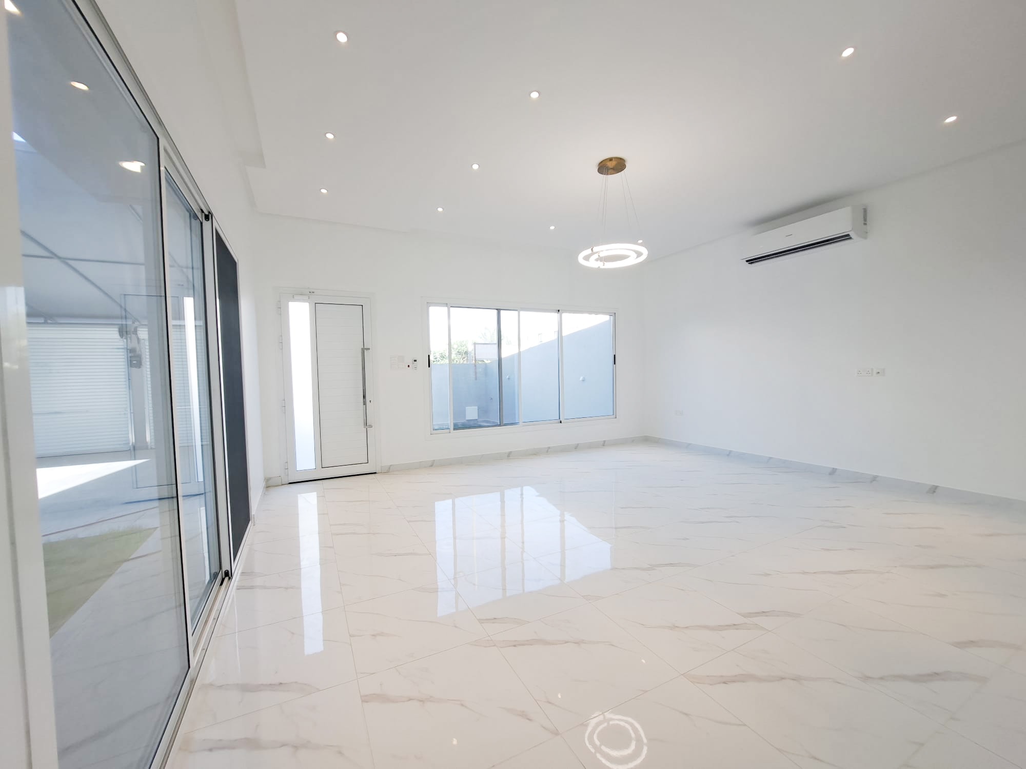 A luxurious white room with a sliding glass door.