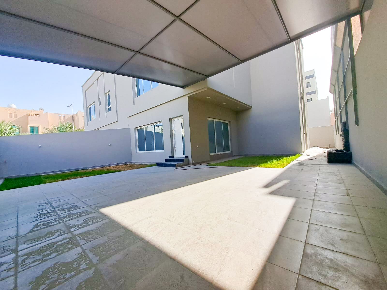 A Luxury 4BR Villa in the middle of a courtyard with a grassy area, available For Sale.