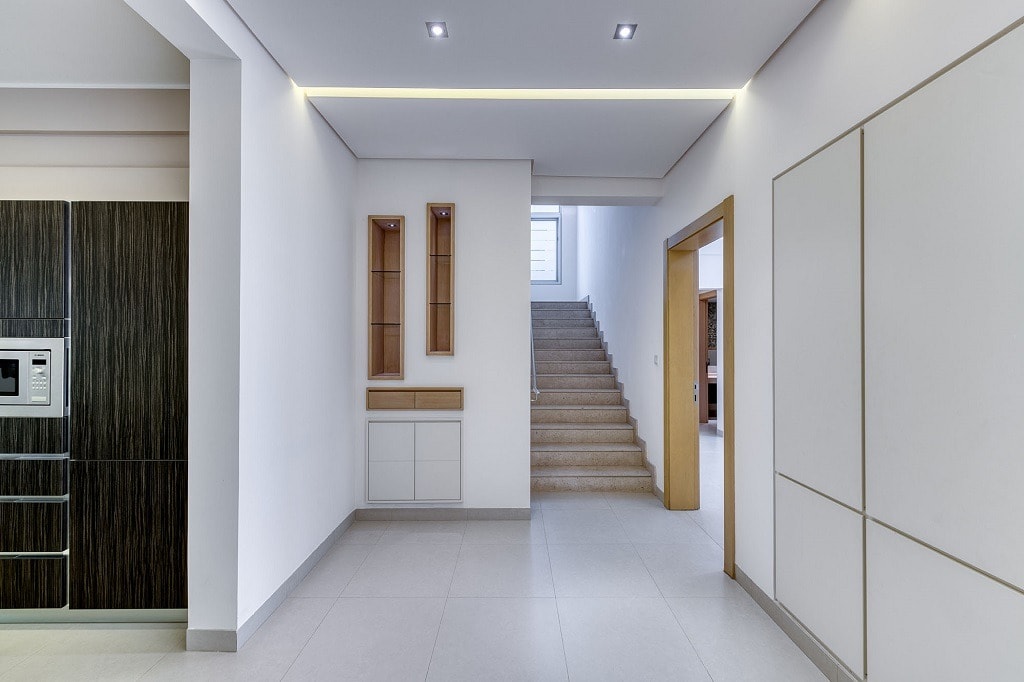 A hallway in a modern home with luxurious villa features and white cabinets.