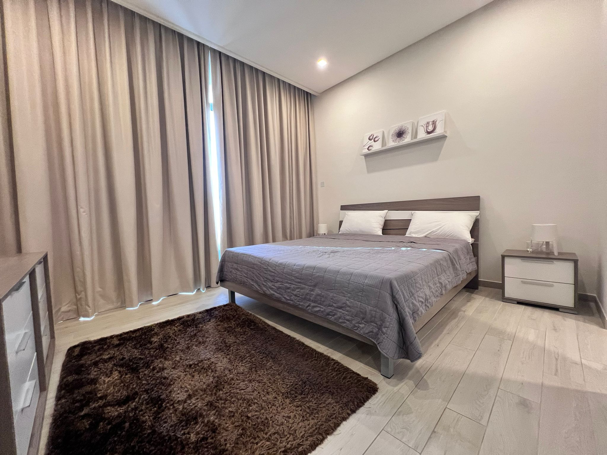 A luxury bedroom with a bed and a bedside table in Juffair.