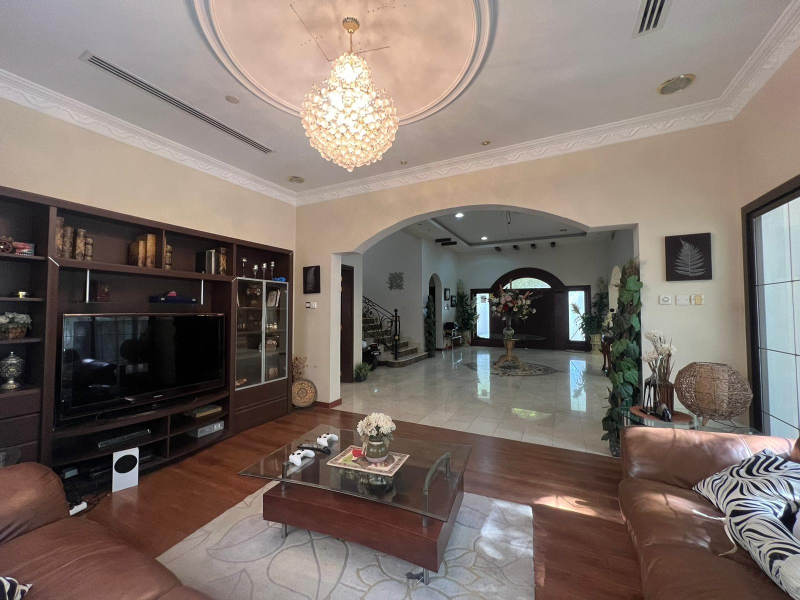 A living room with leather furniture and a chandelier.