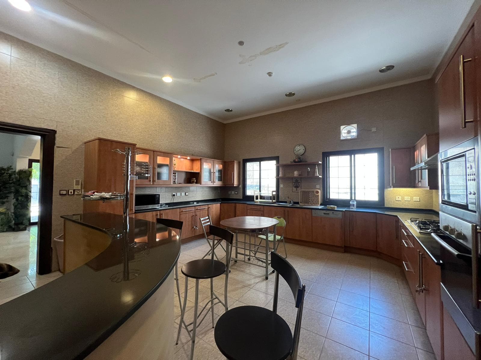 An auto draft kitchen with a large counter top and bar stools.