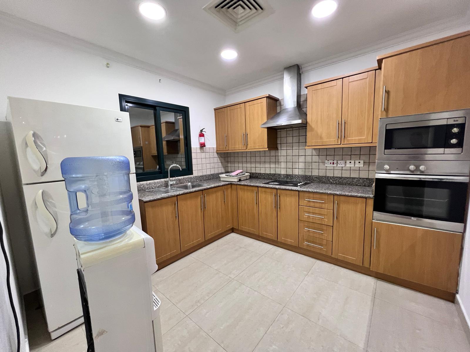 A kitchen with stainless steel appliances and wooden cabinets.