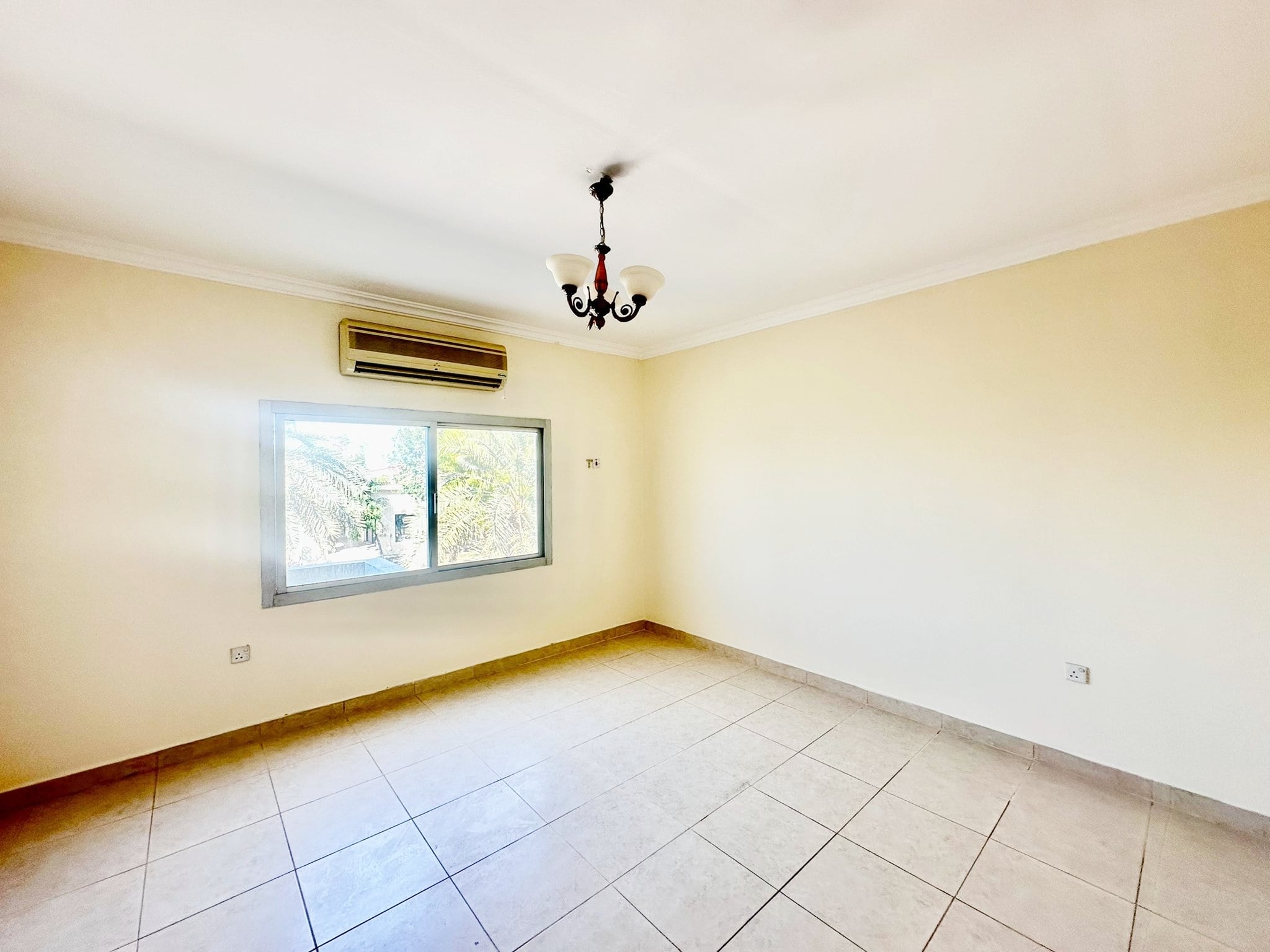 A spacious villa with three bedrooms, featuring an empty room on the second floor with tiled floors and a ceiling fan.