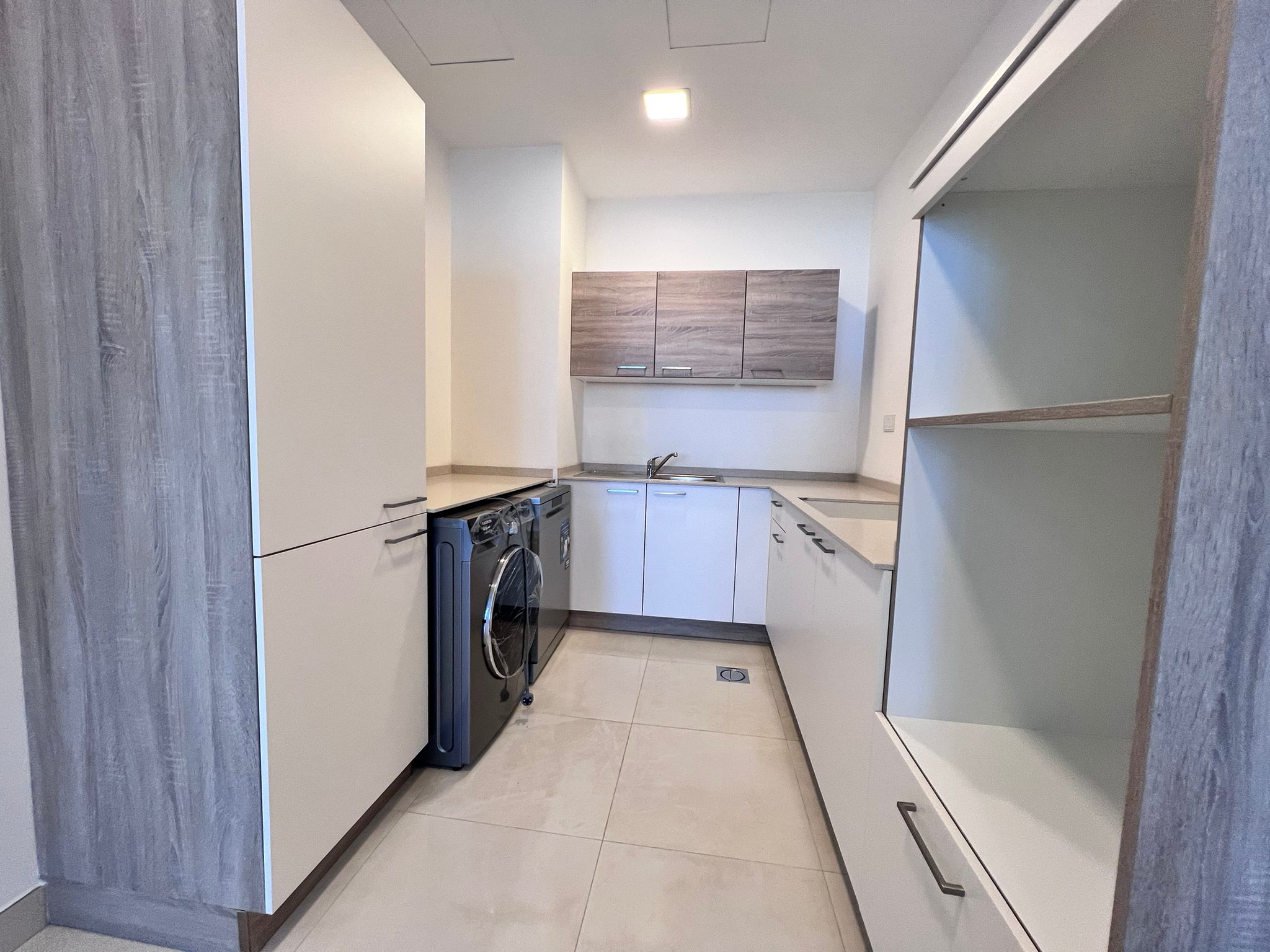 A small luxury kitchen in Juffair with a washer and dryer in a 2 bedroom apartment.