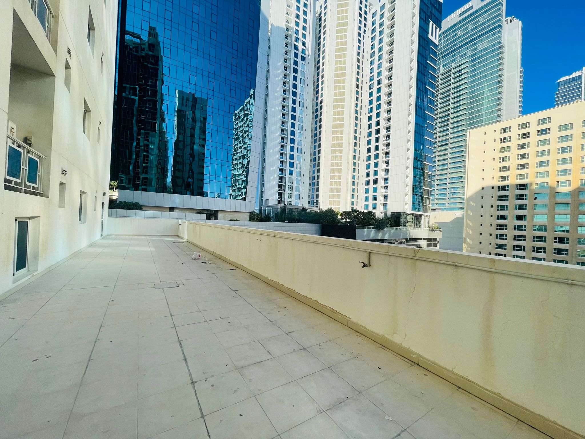 A 2BR apartment with a balcony overlooking the tall buildings of Juffair city.