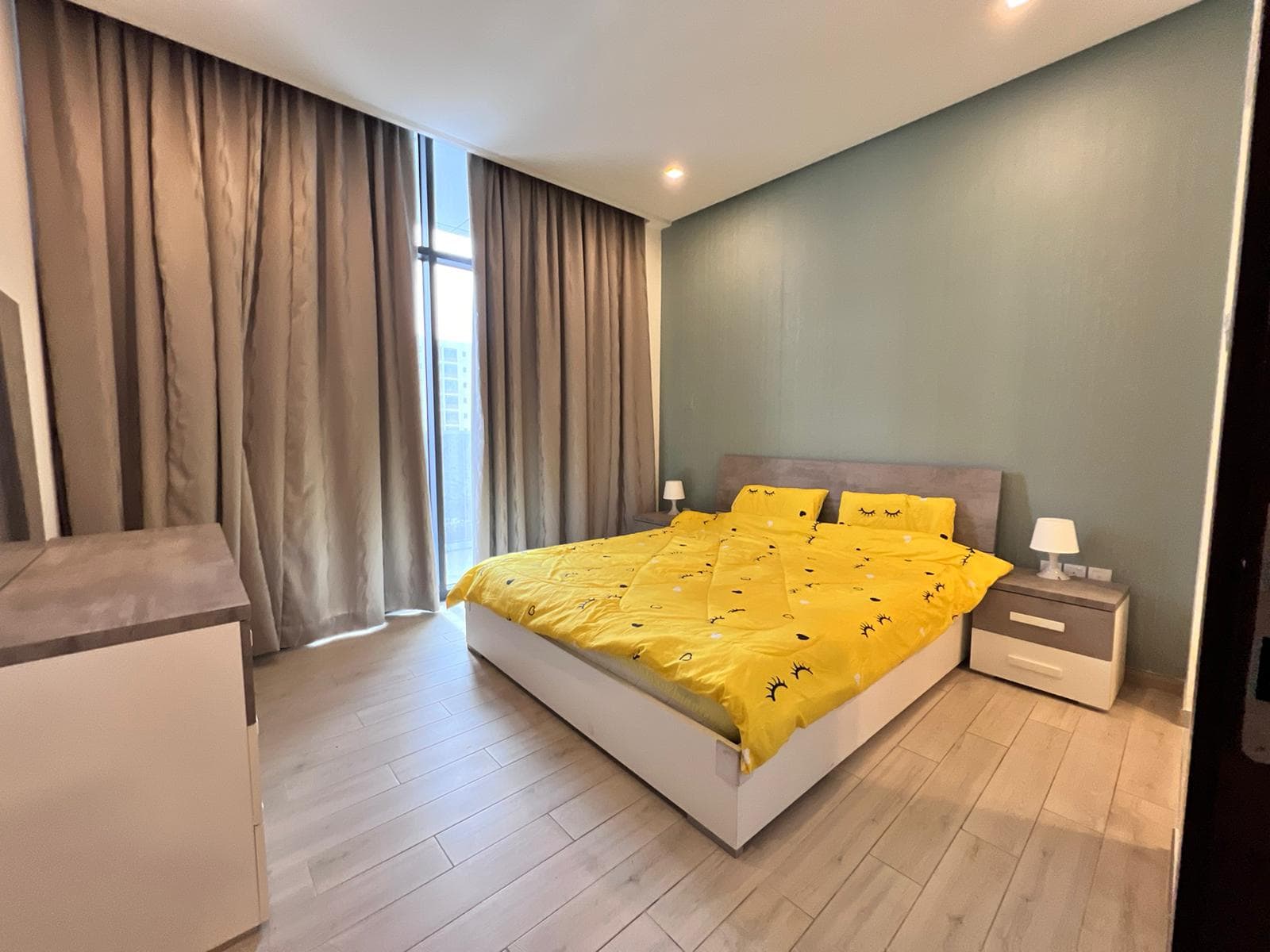 A bed with yellow sheets in a room with curtains, optimized for SEO.