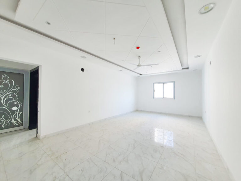 غرفة فارغة ذات جدران بيضاء وأرضيات من البلاط.