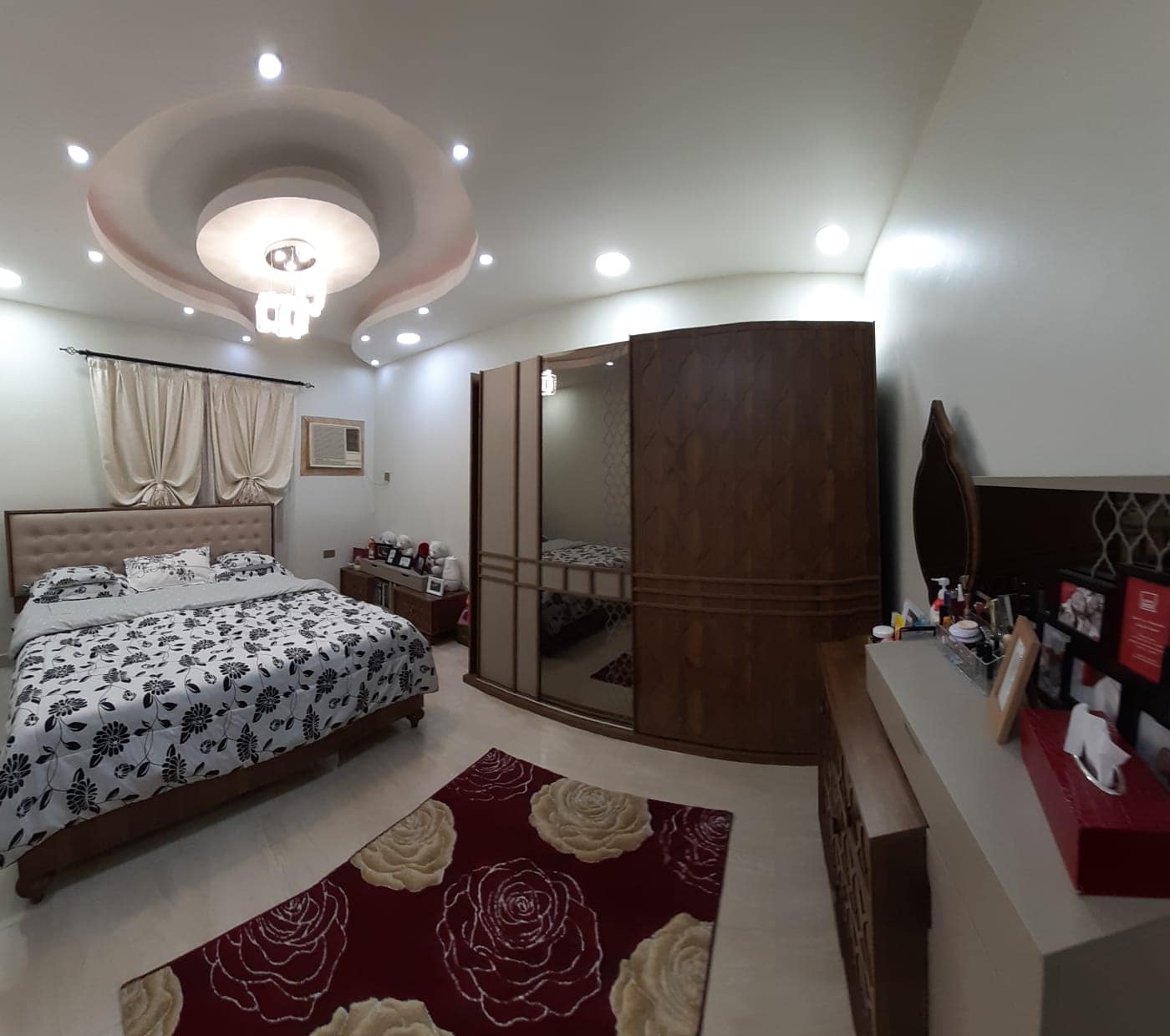 A 360 degree view of a bedroom with a bed, dresser, and apartment.