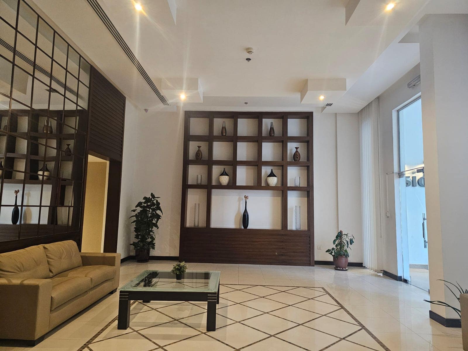 A flat lobby with a coffee table and a glass wall available for rent in Juffair.