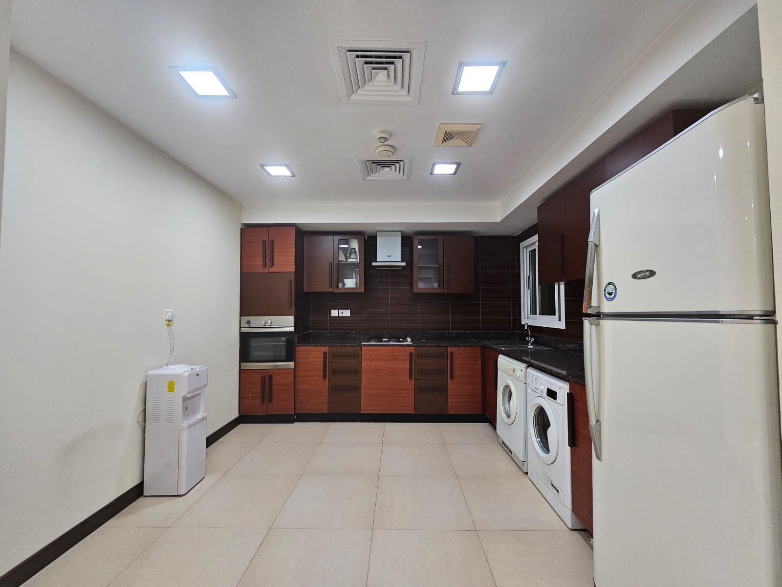 A juffair flat for rent with a kitchen equipped with a washer and dryer.