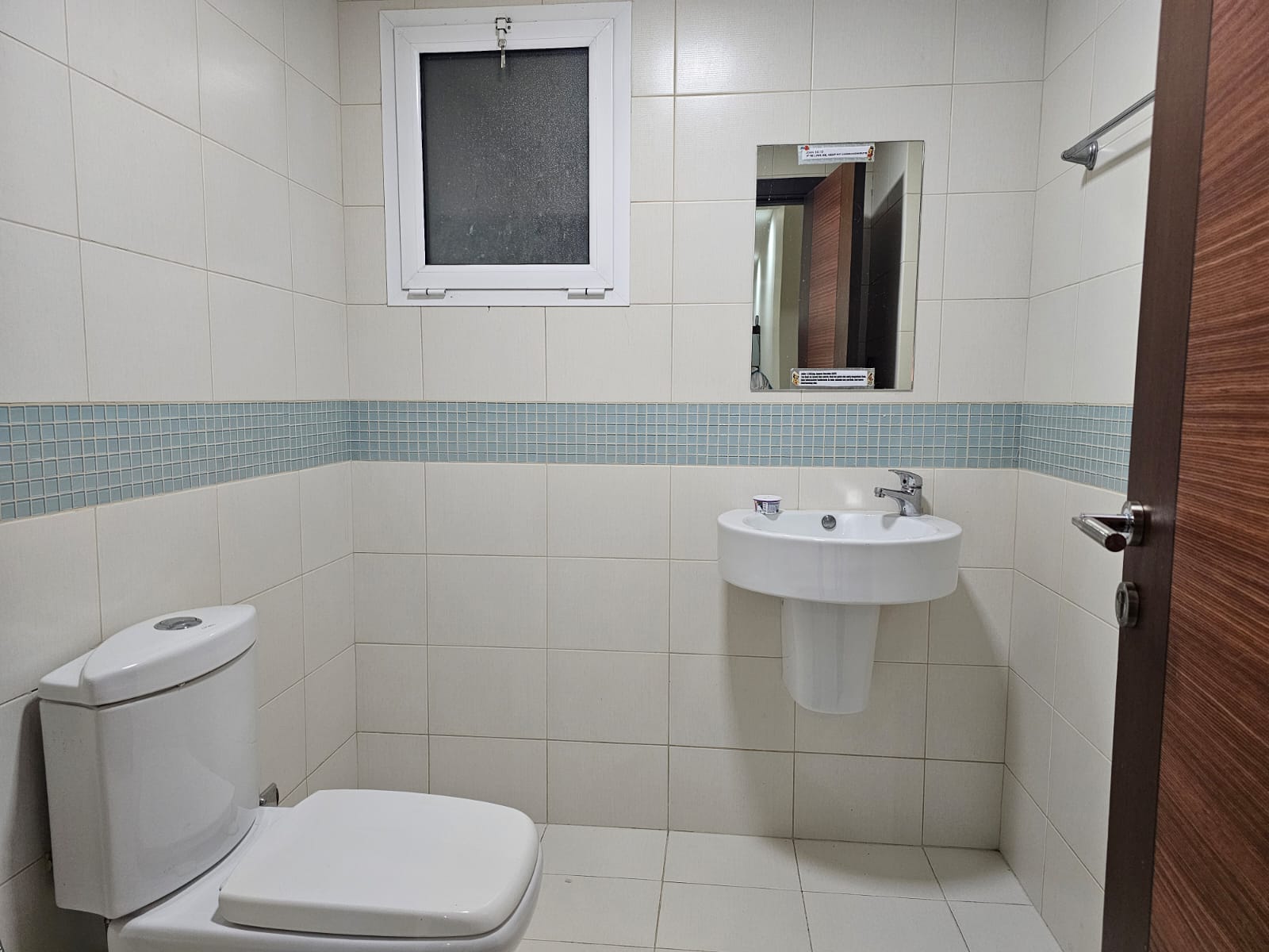 A small bathroom for rent in Juffair, equipped with a toilet and sink.