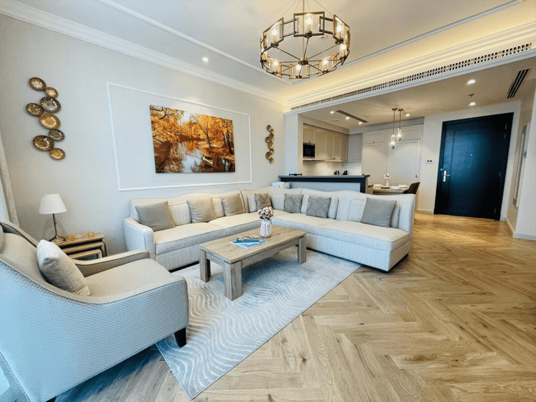 A living room with white furniture and wooden floors.