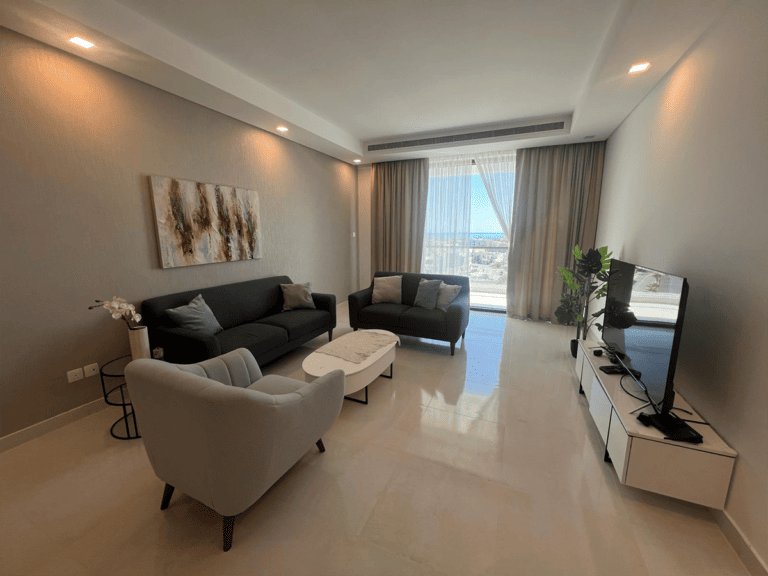 AMWAJ: A stunning flat for rent in Amwaj, boasting a spacious living room adorned with stylish furniture and offering breathtaking ocean views.