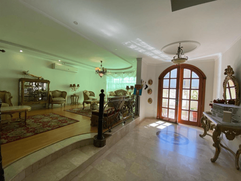 A large living room in a villa with a fireplace and large windows for rent in Galali.
