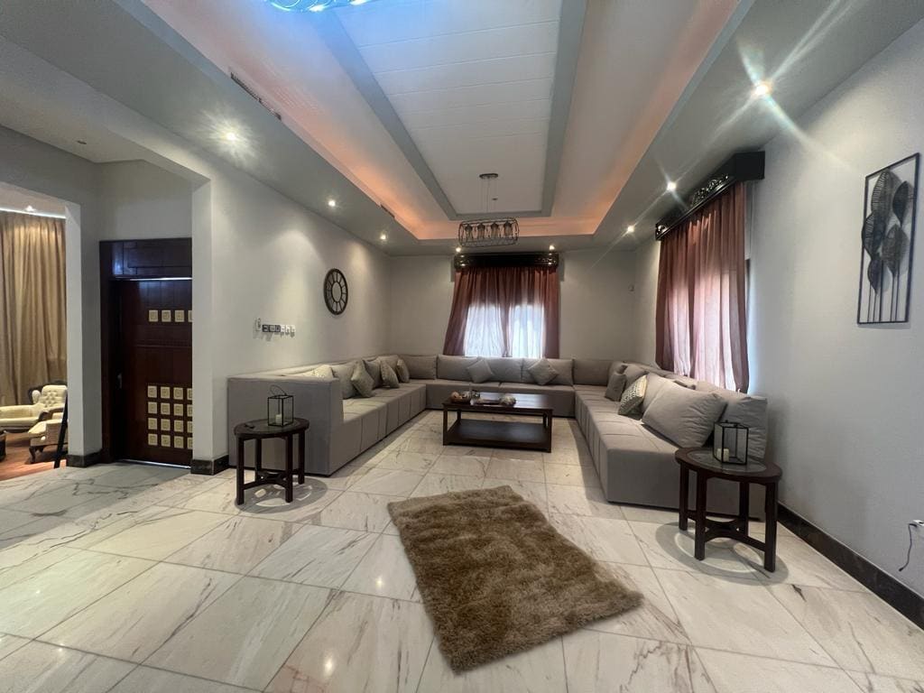 A Juffair villa for rent with a living room featuring a luxurious couch and elegant coffee table.