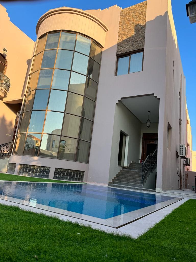 A villa with a swimming pool in front of it available for rent in Juffair.