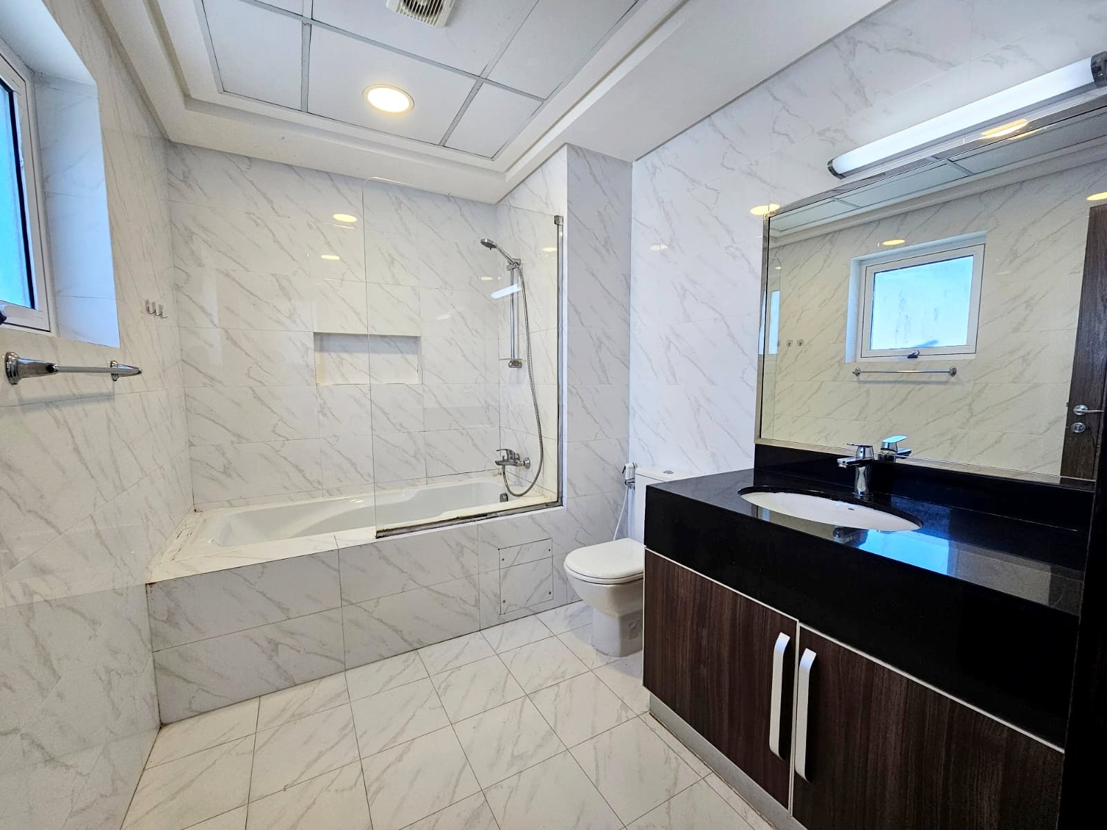 A bathroom with marble counter tops and a bathtub is perfect for those seeking luxury.