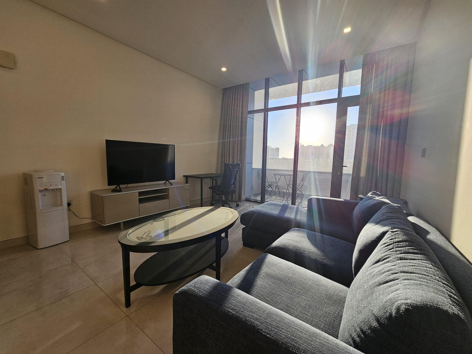 A living room with a cozy couch and a large TV.