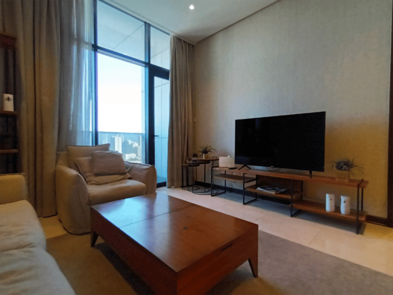 A luxury 1BR living room with a flat screen TV and a sea view.
