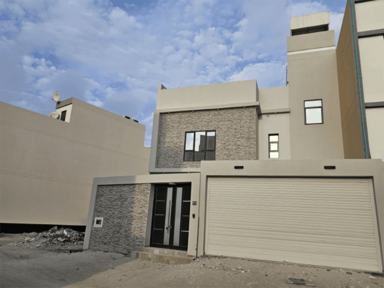 A villa for sale with a garage in front of it, located in the Sitra area.