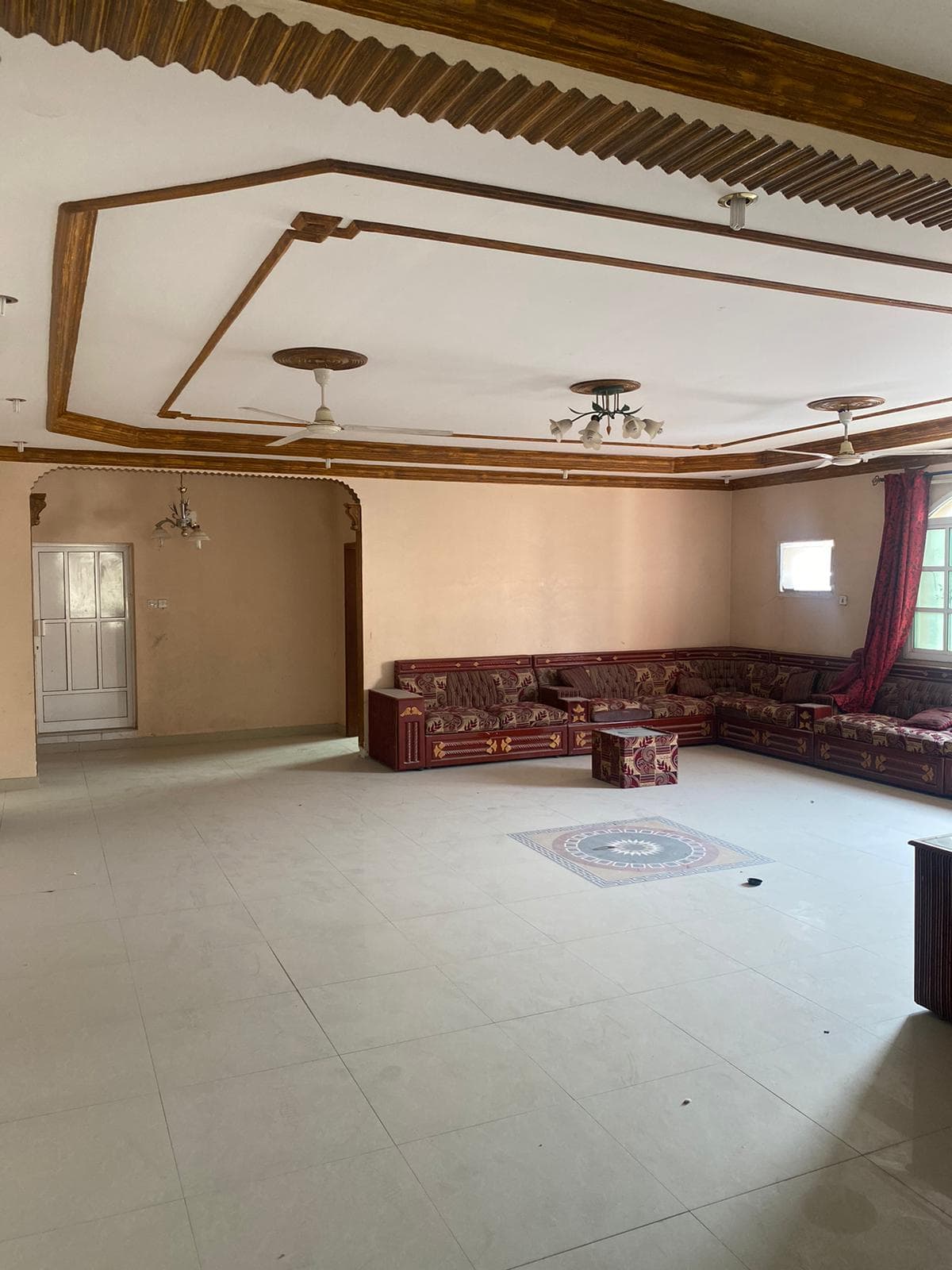 A living room in an Isa Town villa for sale, with couches and a ceiling fan.