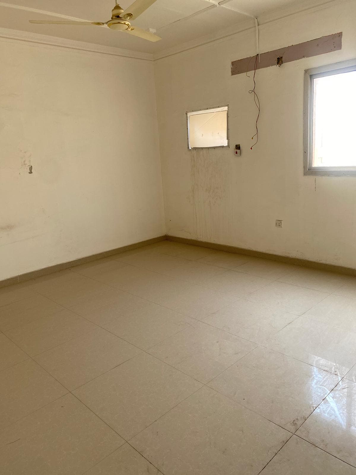 A Villa for sale: An empty room with a window and a fan in Isa Town.