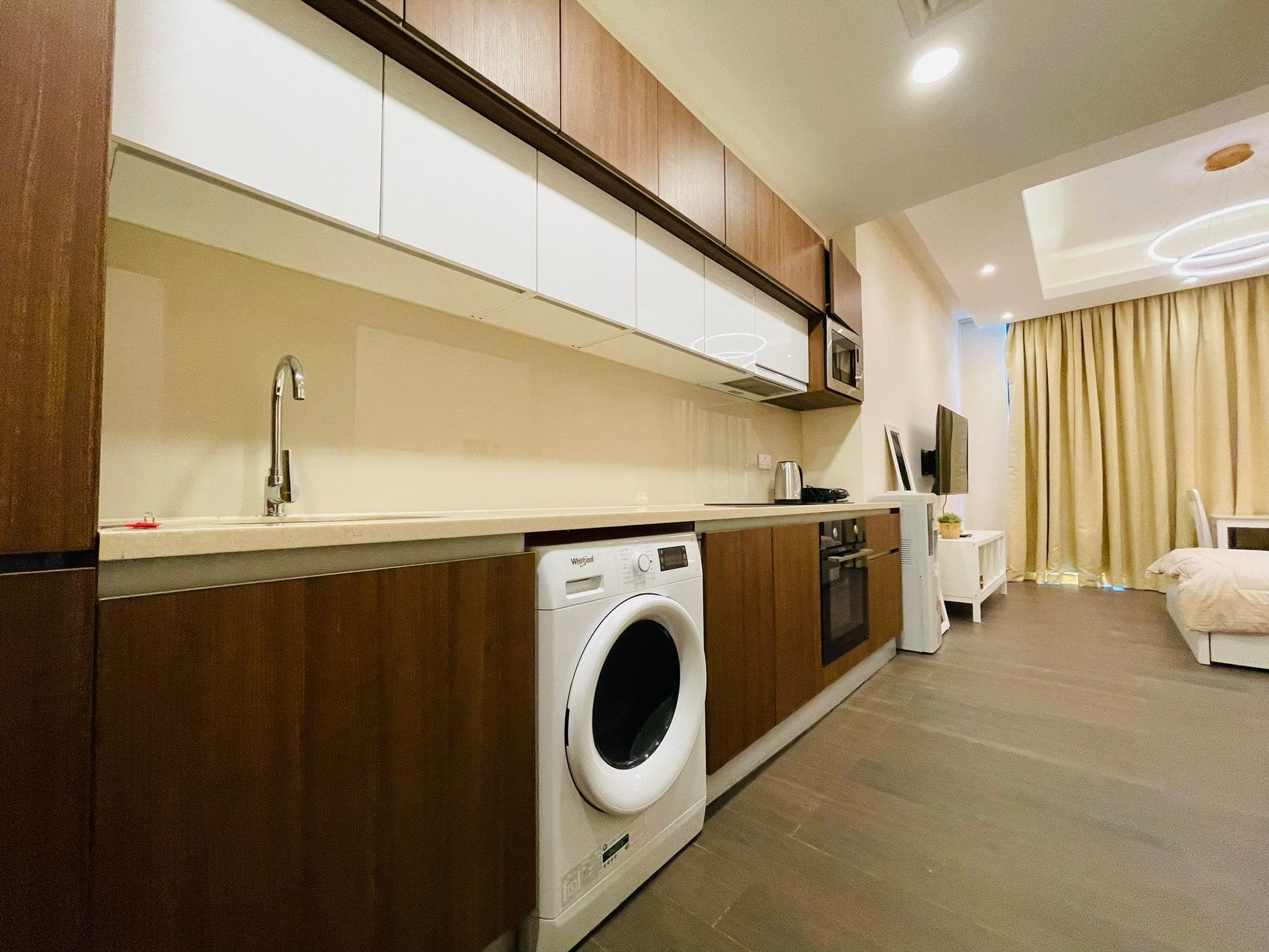 A Luxury Studio in Juffair with a modern living room, including a washing machine and a bed.