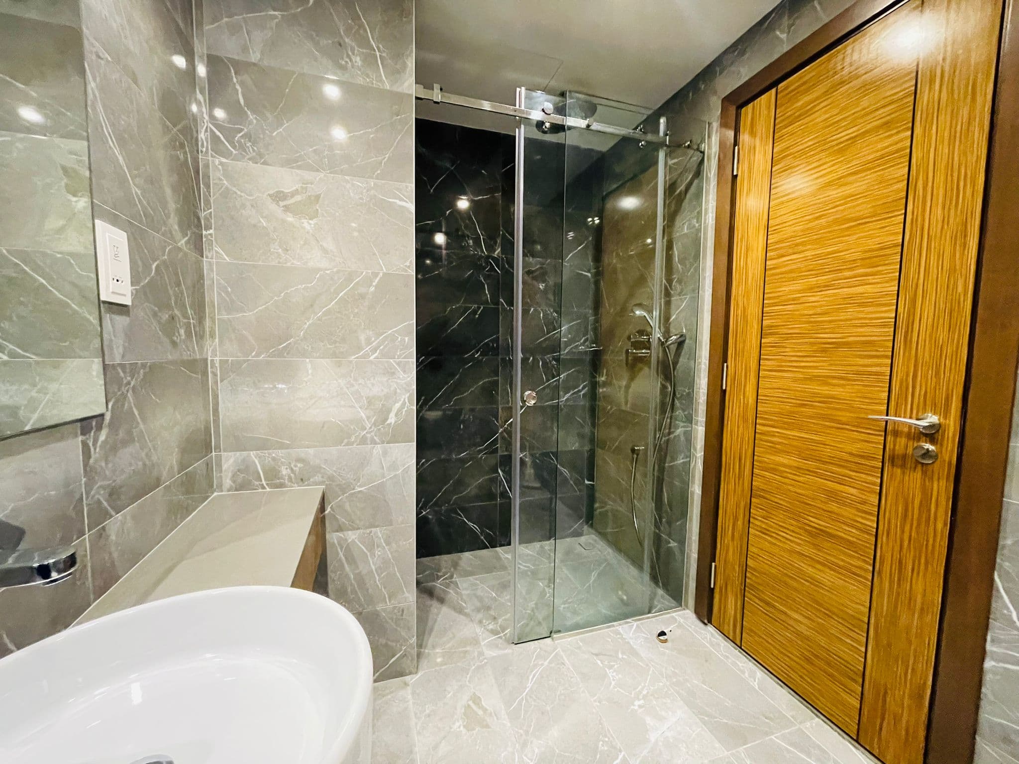 A luxury studio in Juffair with a modern bathroom featuring a glass shower door.