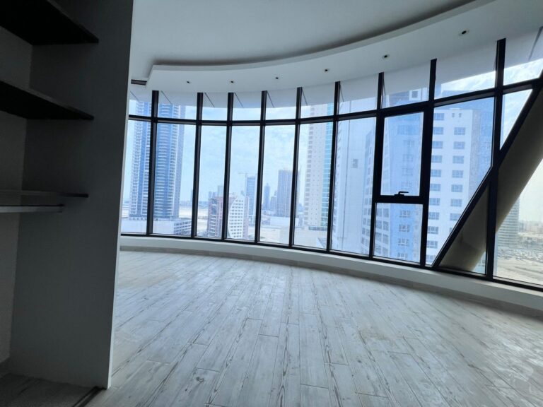 An empty luxury one bedroom apartment with a large window overlooking the city.