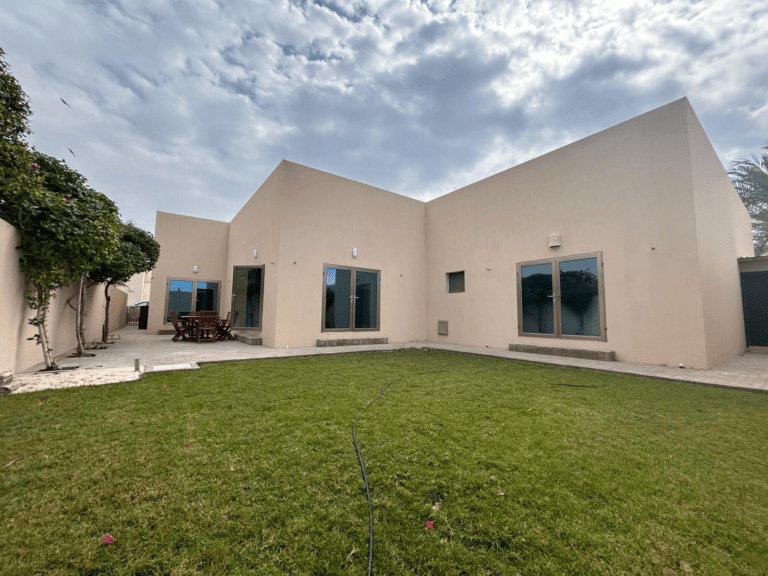 Modern villa for rent, single-story with a small lawn and outdoor seating area under a clear sky in the Hamala area of the Compound Hamala.