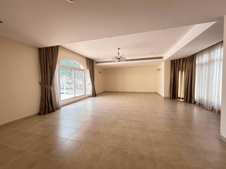 Spacious empty room in Villa Hamala with large windows and tiled flooring.