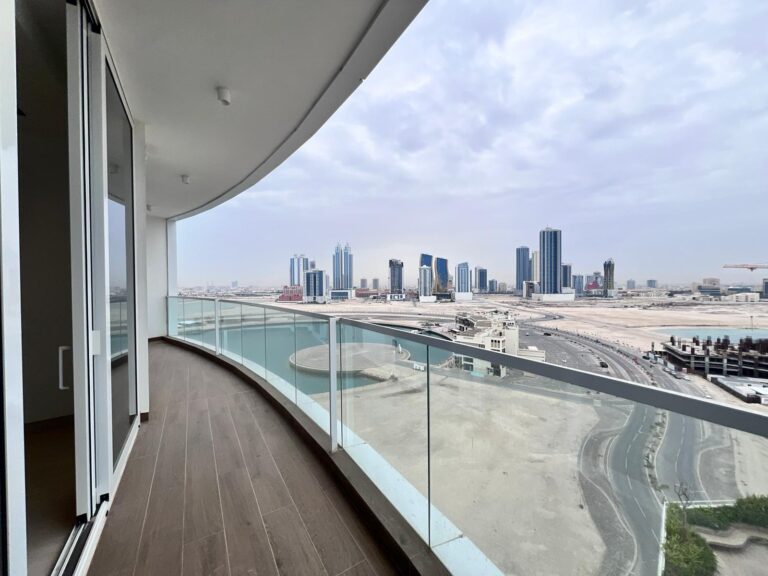 View from a high-rise balcony of a brand new apartment, overlooking a modern cityscape with skyscrapers, clear roads, and the glistening Bahrain Water Bay.